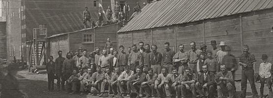 black and white photo of workers standing and sitting